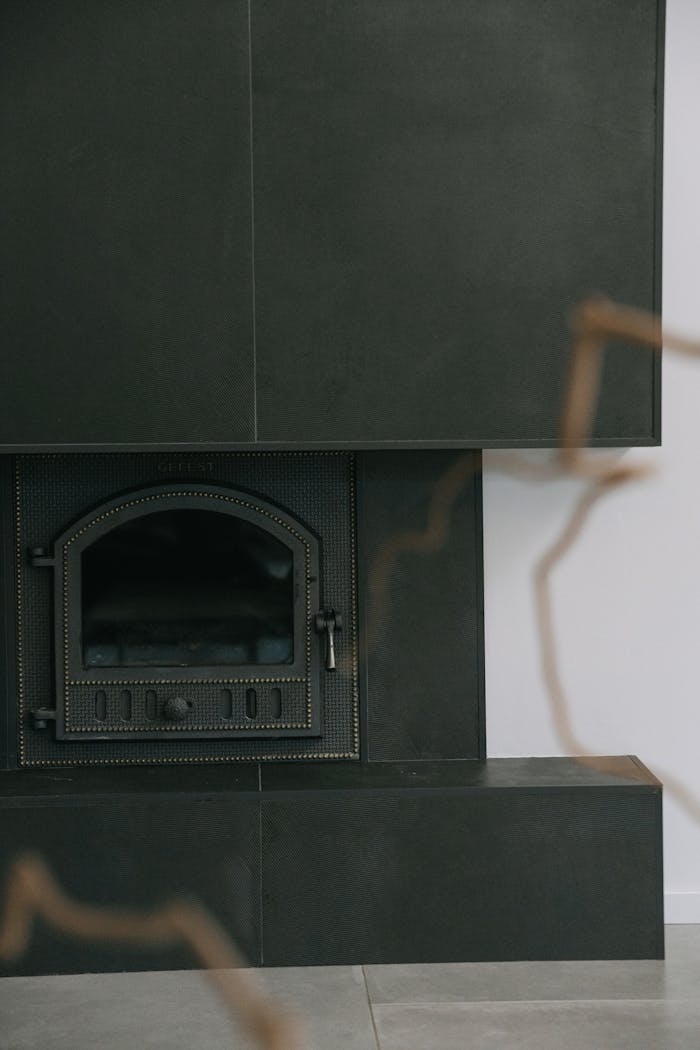 A sleek black fireplace with a modern design element in a minimalist interior space.